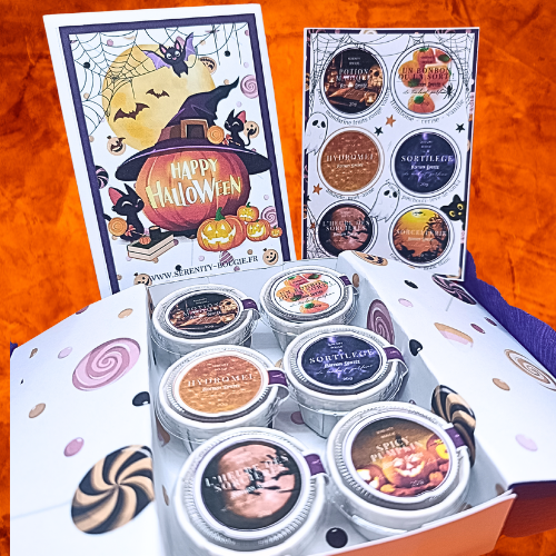 Vue d'ensemble du coffret de 6 fondants parfumés Halloween "Happy Halloween" ouvert, avec carte et fondants assortis sur des citrouilles lumineuses.