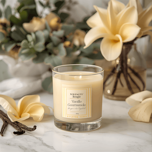 Bougie parfumée Vanille Gourmande Serenity Bougie dans son pot en verre transparent et réutilisable, avec son étiquette minimaliste blanche. La mèche en coton est visible sur le dessus de la cire de soja blanche.